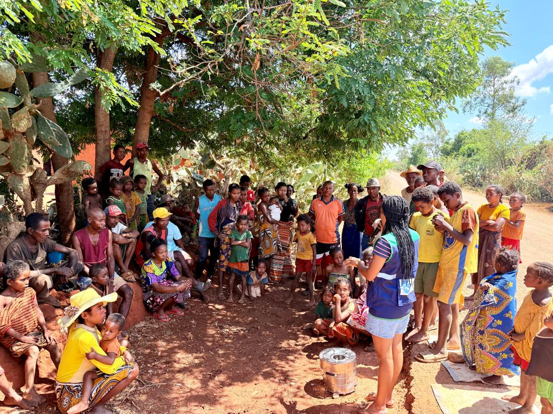 A community gathered under a tree at Ianabinda for a public meeting